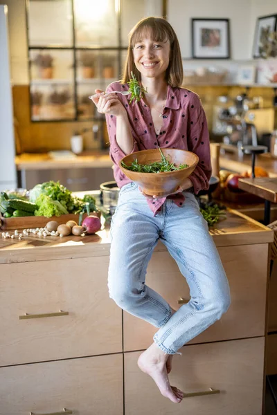 Γυναίκα τρώει υγιεινή σαλάτα στην κουζίνα στο σπίτι — Φωτογραφία Αρχείου