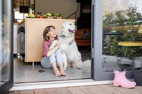 Vrouw zit samen met haar schattige enorme hond thuis — Stockfoto