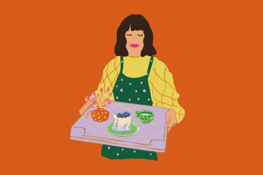 Ev hanımı elinde pasta ve çiçekle tepsi tutuyor.