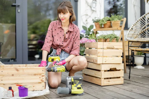 Ama de casa reparaciones cajas de madera en la terraza — Foto de Stock