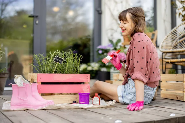 Mulher pintando caixa de madeira, fazendo alguns trabalhos domésticos renovando ao ar livre — Fotografia de Stock