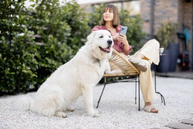 Bahçesinde köpeği olan mutlu bir kadın.