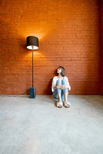 Kvinne som sitter alene hjemme – stockfoto