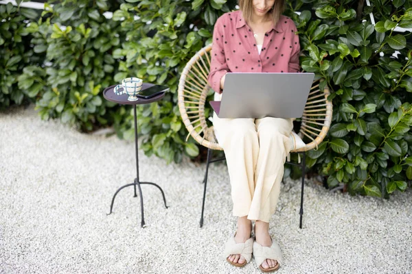 Mujer trabaja en el ordenador portátil en el jardín — Foto de Stock