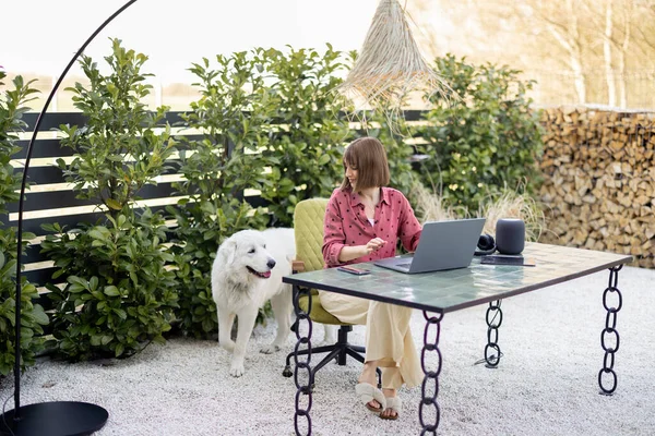 Kadınlar rahat bir bahçede çalışırken köpeğini önemserler.