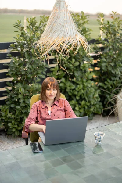 Woman works on laptop online in the garden outdoors — Stock Photo, Image