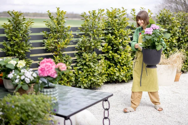 Жінка доглядає за квітами в саду — стокове фото