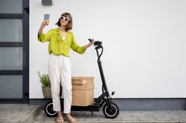 Evde scooter 'ı olan bir kadın telefonda konuşuyor.