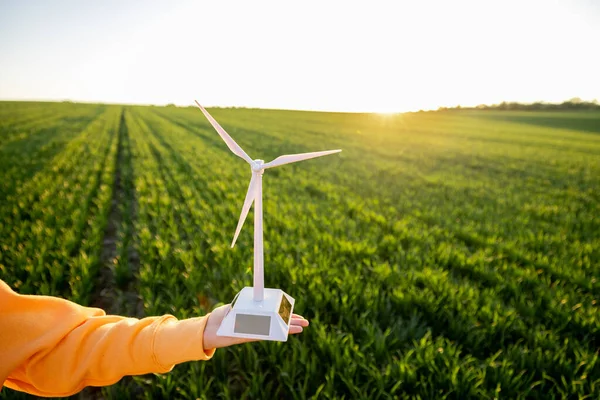 Person holds toy wind generator on field — Stock Photo, Image