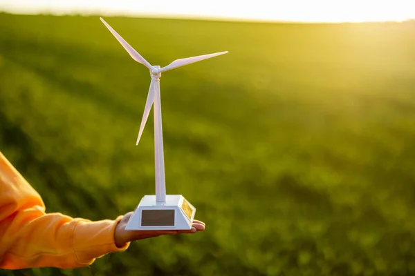 Person holds toy wind generator on field — Stock Photo, Image