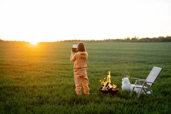 Orang mengambil foto matahari terbenam yang indah saat bersantai di lapangan — Stok Foto