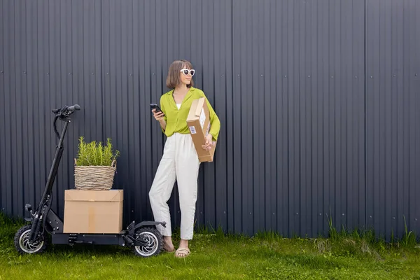 Woman delivering goods by electric scooter — Foto de Stock