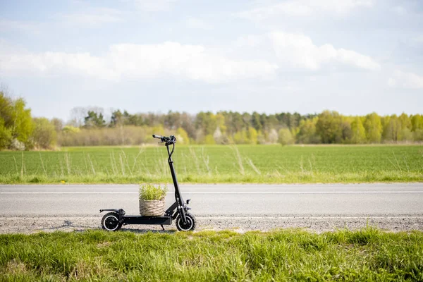 Tarla yolunda saksısı olan elektrikli scooter.