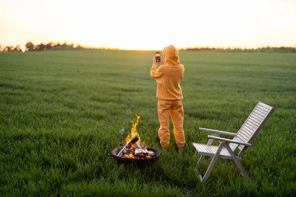 Person takes photo of beautiful sunset while relaxing on field — 图库照片