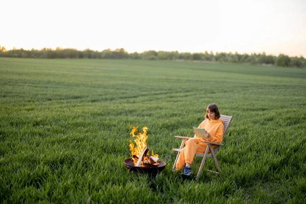 Woman relax near the fireplace with her dog on field – stockfoto