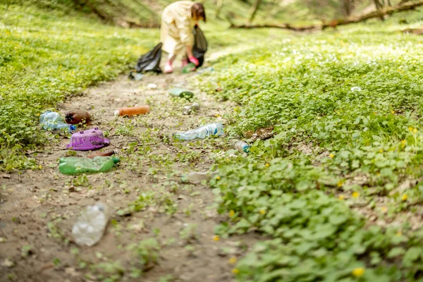 Doğaya saçılmış plastik çöpleri toplayan kişi