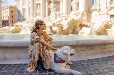 Köpekli kadın Roma 'daki ünlü di Trevi çeşmesinin yanında.