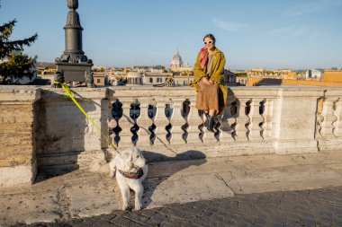 Köpekli kadın, eski Roma şehrinin güzel manzarasının tadını çıkarıyor.