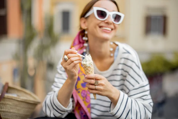 Портрет молодой веселой женщины, кушающей мороженое на открытом воздухе — стоковое фото