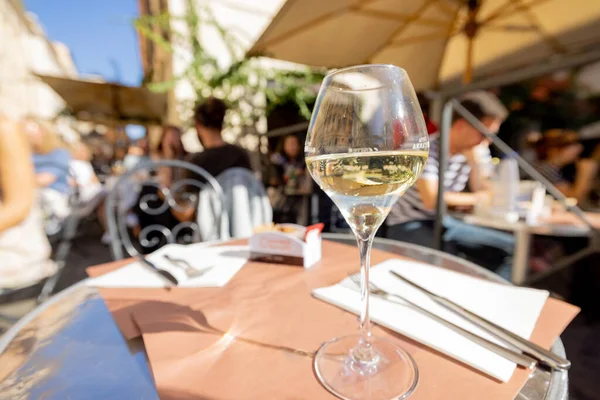 Szklanka białego wina na stole restauracyjnym na świeżym powietrzu — Zdjęcie stockowe