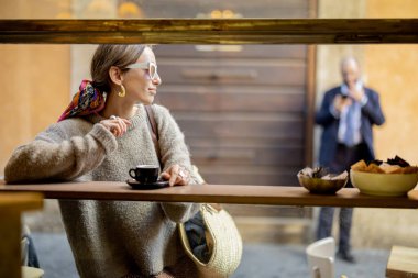 Geleneksel İtalyan kahvesinde espresso içen kadın.