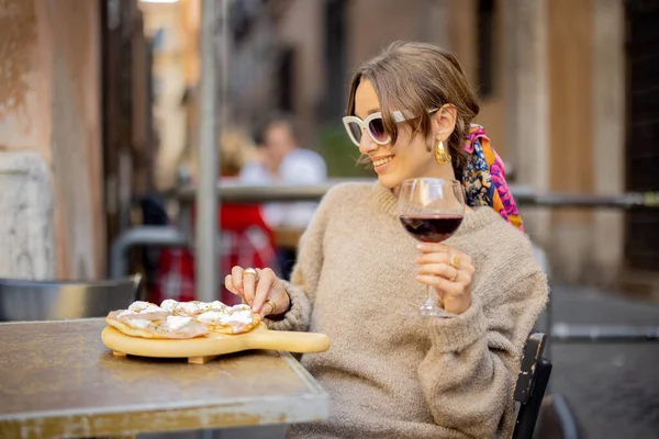 Жінка їсть піцу в ресторані на вулиці. — стокове фото