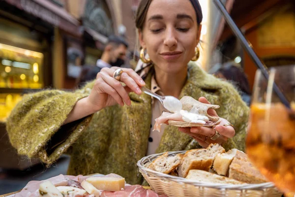 Жінка з італійськими закусками і п'є на відкритому повітрі в барі. — стокове фото