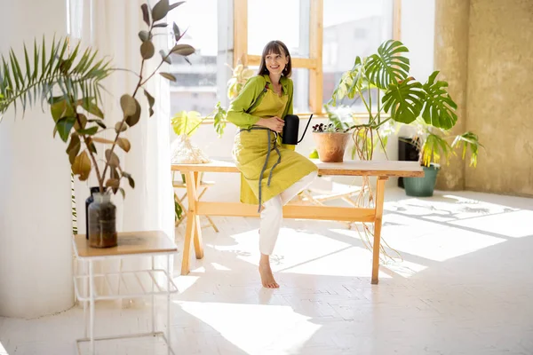 女人在室内照料绿色植物 — 图库照片