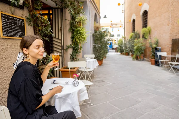 Γυναίκα κάθεται με κρασί στο ιταλικό εστιατόριο στο ζεστό δρόμο — Φωτογραφία Αρχείου