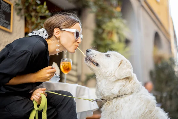 Femme manger des pâtes avec son chien blanc mignon au restaurant — Photo