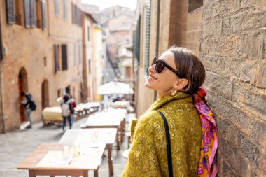 Eski Siena şehrindeki dar ve rahat caddede yürüyen Sylish kadını