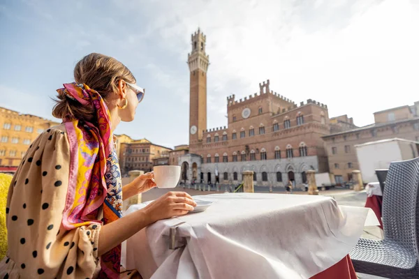 Nő reggelizik a szabadtéri kávézóban gyönyörű kilátással a főtéren Siena város, Olaszország — Stock Fotó