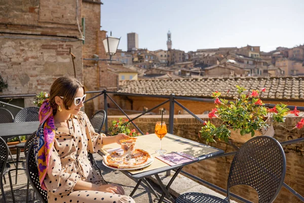 Giovane donna a pranzo con pizza e vino al ristorante all'aperto della città di Siena — Foto Stock