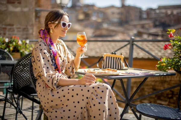 Mladá žena obědvá s pizzou a vínem v venkovní restauraci ve městě Siena — Stock fotografie