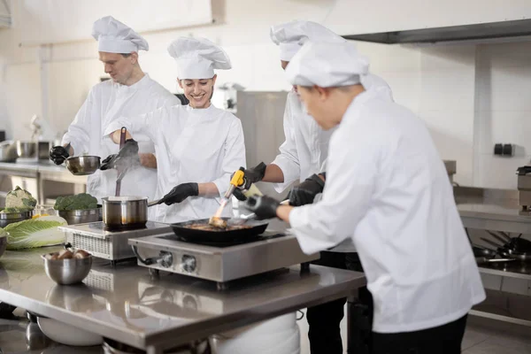여러 인종으로 이루어진 직업 요리 팀 이 주방에 있는 식당에서 식사를 준비하는 모습 — 스톡 사진