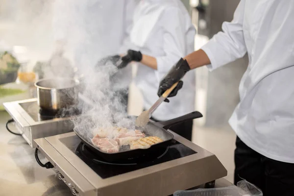 Cooks preparing food in professional kitchen, close-up view — Stock Photo, Image