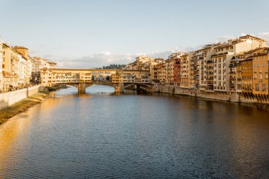 İtalya 'nın Floransa kentinde Arno nehri üzerindeki Ponte Vecchio adlı ünlü eski köprünün gün batımı manzarası. İtalya 'yı gezme, İtalya' yı ziyaret etme kavramı