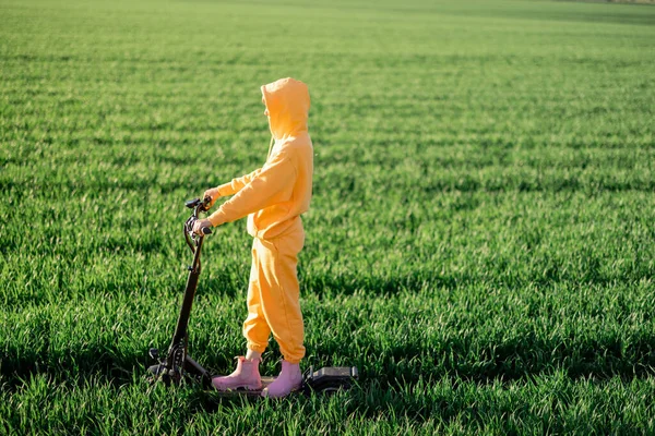 Young Person Overalls Riding Electric Scooter Green Field Sunset Concept — Stock Fotó