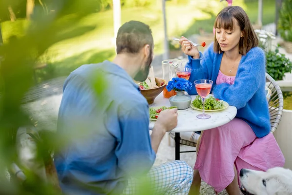 年轻快乐的夫妻在夏天一起坐在后院聊天 吃着健康的沙拉 玩得很开心 — 图库照片