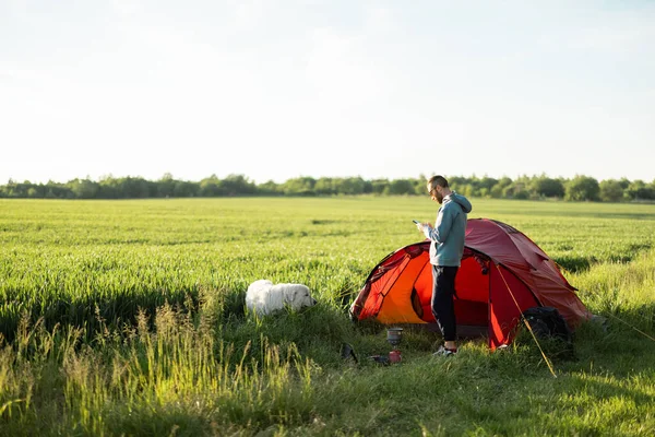 Muž Stojí Psem Greenfieldu Zatímco Cestuje Stanem Přírodě — Stock fotografie