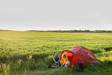 Bir çift yaz tatilini yeşil alandaki kamp alanında bir köpekle geçiriyor. Gün batımında güzel buğday tarlasında geniş bir manzara. Erkek ve kadın doğada çadır kurarak seyahat ederler.