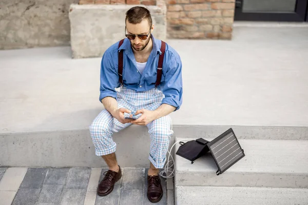 Stylish Man Use Smart Phone Charge Portable Solar Panel While — Stockfoto