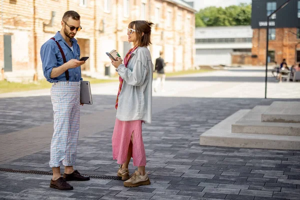 Young Stylish Couple Have Some Conversation While Standing Together Phones —  Fotos de Stock