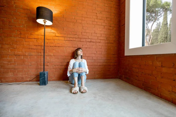 Nuori Nainen Istuu Yksin Lattialla Tyhjässä Huoneessa Lähellä Ikkunaa Lattiavalaisin — kuvapankkivalokuva