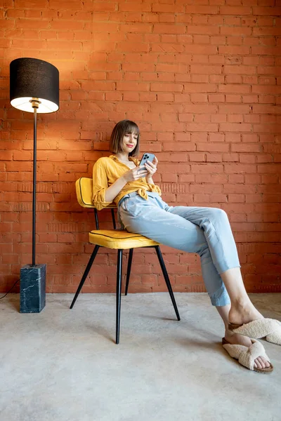 Young Stylish Woman Using Smart Phone While Sitting Chair Floor — Foto de Stock