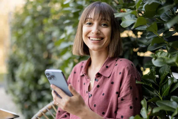 Portrait Young Cheerful Woman Using Smart Phone While Sitting Background — Foto de Stock