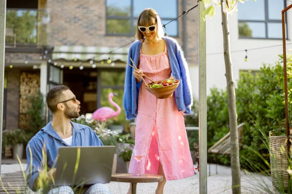 Man Works Laptop While Sitting Backyard Woman Comes Healthy Salad — Fotografia de Stock