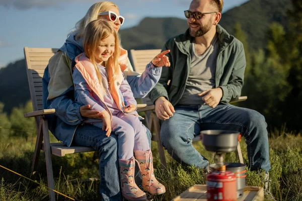 暑假期间 年轻快乐的家庭与小女孩坐在一起野餐的肖像 家人在大自然旅行的时候玩得很开心 — 图库照片