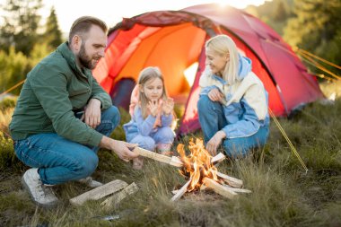 Genç bir çift kamp alanındaki kamp ateşinin yanında küçük bir kızla oturur, doğada çadır kurarak seyahat ederler. Aile yaz tatilini dağlarda yürüyüş yaparak geçirir.