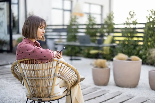 Young Woman Using Phone While Sitting Relaxed Chair Backyard Her — Foto de Stock